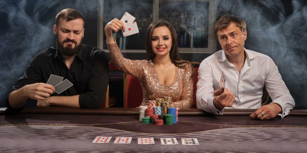 Primo piano di tre amici allegri che giocano a poker al casinò fisico